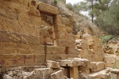 Rear wall and basins of the rock-cut sanctuary.