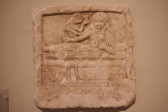 Funerary inscription for Taschinis, who according to the inscription, died young and loved her children. The feet of the bed bear symbols of Osiris and Isis, and Anubis stands over the woman. Probably from Zagazig, Egypt. Dated to the 1st to 2nd century CE. Szépművészeti Múzeum.