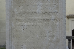 Inscription noting the construction of works by Domitian, whose name is removed in damnatio memoriae, in 93 CE. Found on the Via Flaminia outside Rimini, now in the lapidary garden of the Museo della Città.