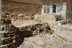 Excavated remains of the tower at Plaza San Isidoro  at left with the earlier fortification wall at the right.