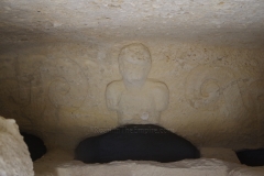 Detail of the interior of a tomb with a relief of a figure.