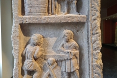 One side of the three-sided so called 'stele of the winegrowers'. These reliefs depicting the transfer of wine to a smaller vessel and the sawing of wood. Dated to the late 2nd century CE. Musée de La Cour d'Or de Metz.