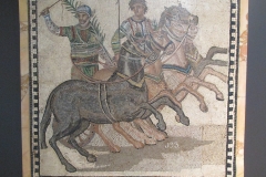 Mosaic of a quadriga and victorious charioteer of the factio prassina. Dated to the 3rd century CE, from Rome.