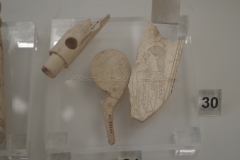 Bone flute piece, spoon, and plaque with an image of a woman. Dated to the 6th century BCE.