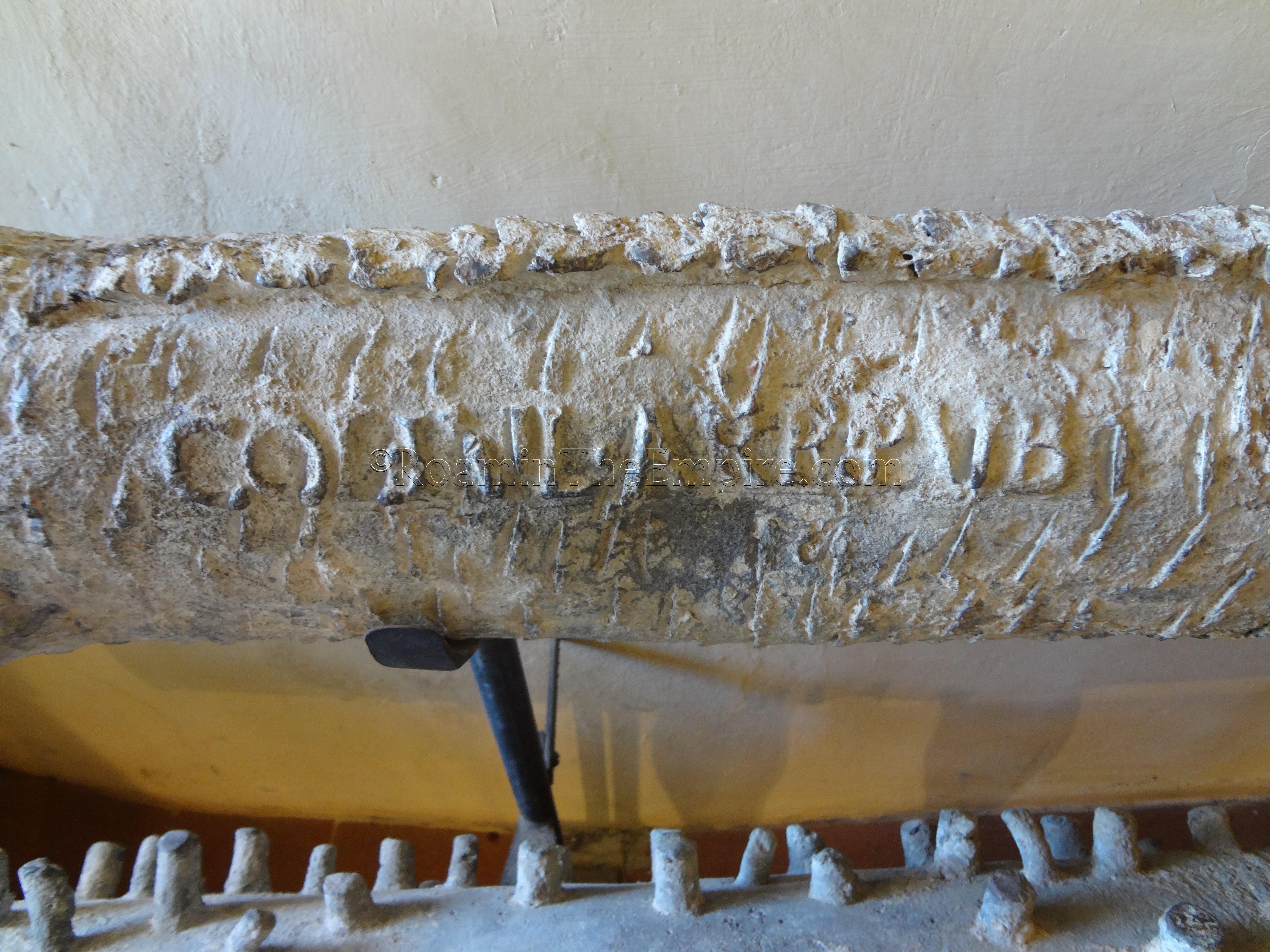 Detail of the inscription on a lead pipe with the name of the city, reading 'Colonia Juliensis Arretinorum Publice'.