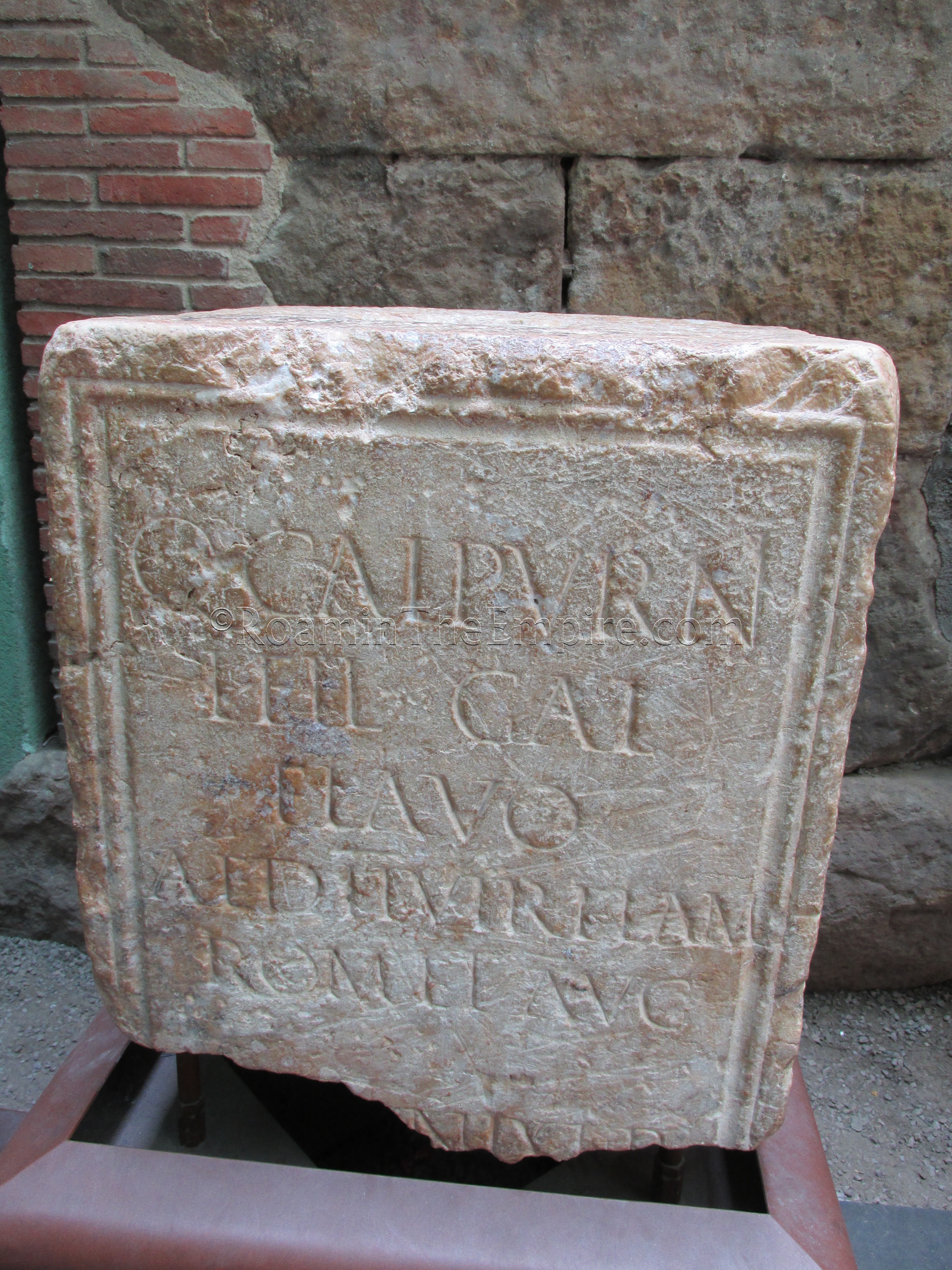 Honorary inscription of Quintus Calpurnius Flavus, a Sacerdos Augustalis, among other titles, currently displayed in the courtyard of the Temple of Augustus, originally from the forum.