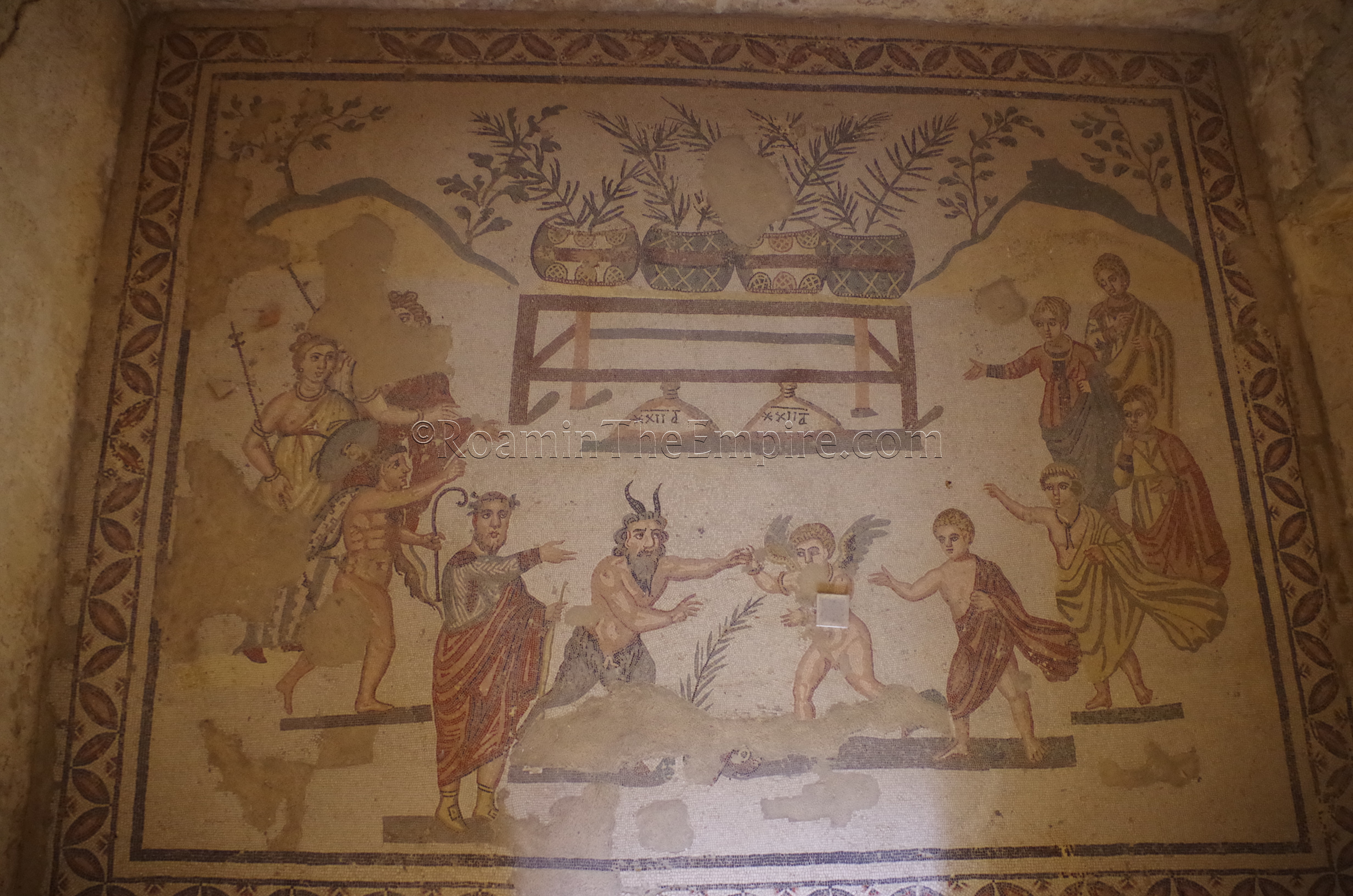 Antechamber of a cubiculum decorated with a contest between Pan and Eros, with Bacchic imagery present. The figures behind Eros are possibly those of the domina, her children, and a maidservent. Villa Romana del Casale.