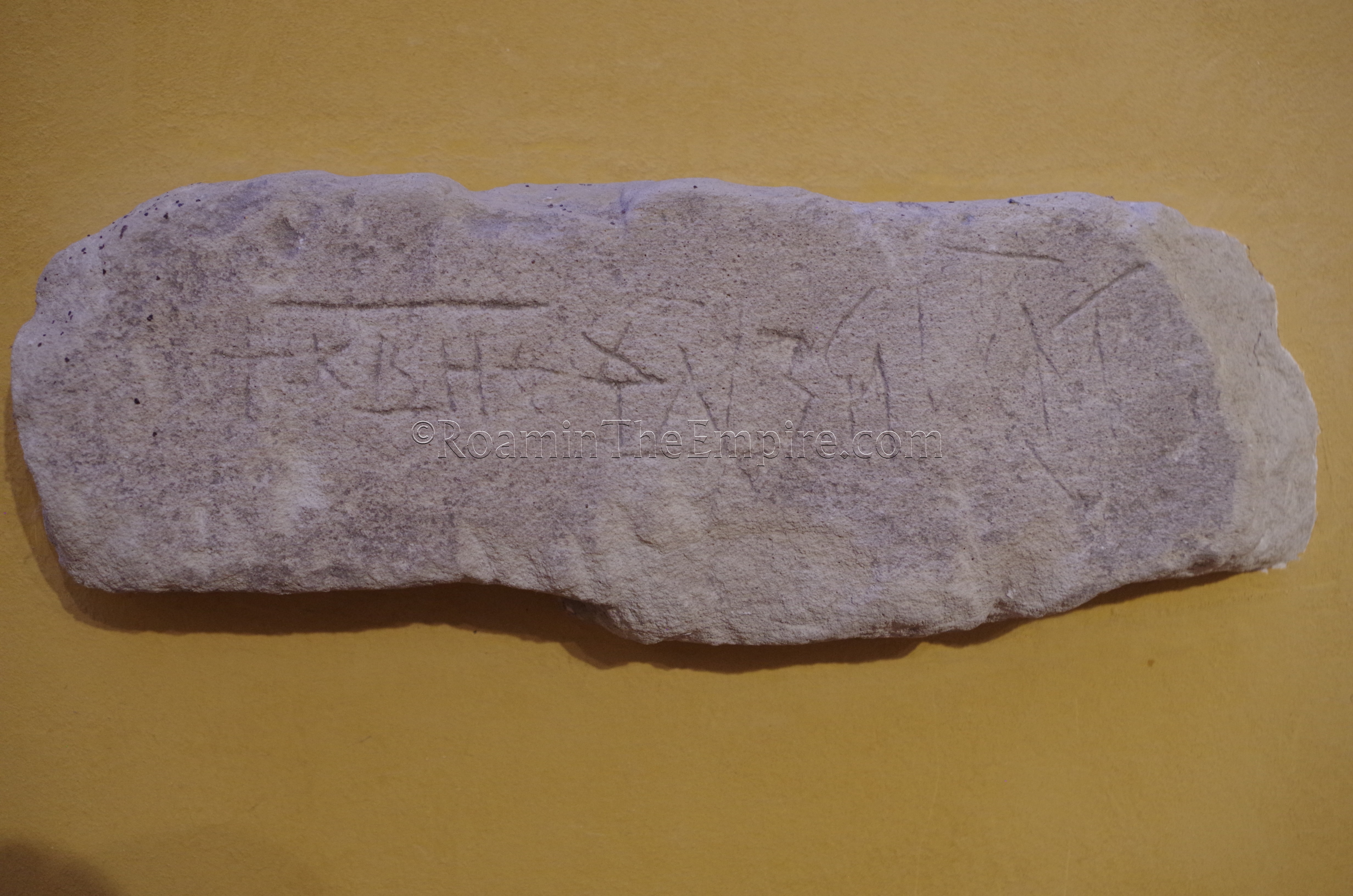 Tufa brick with an inscription. Villa Romana di Patti.