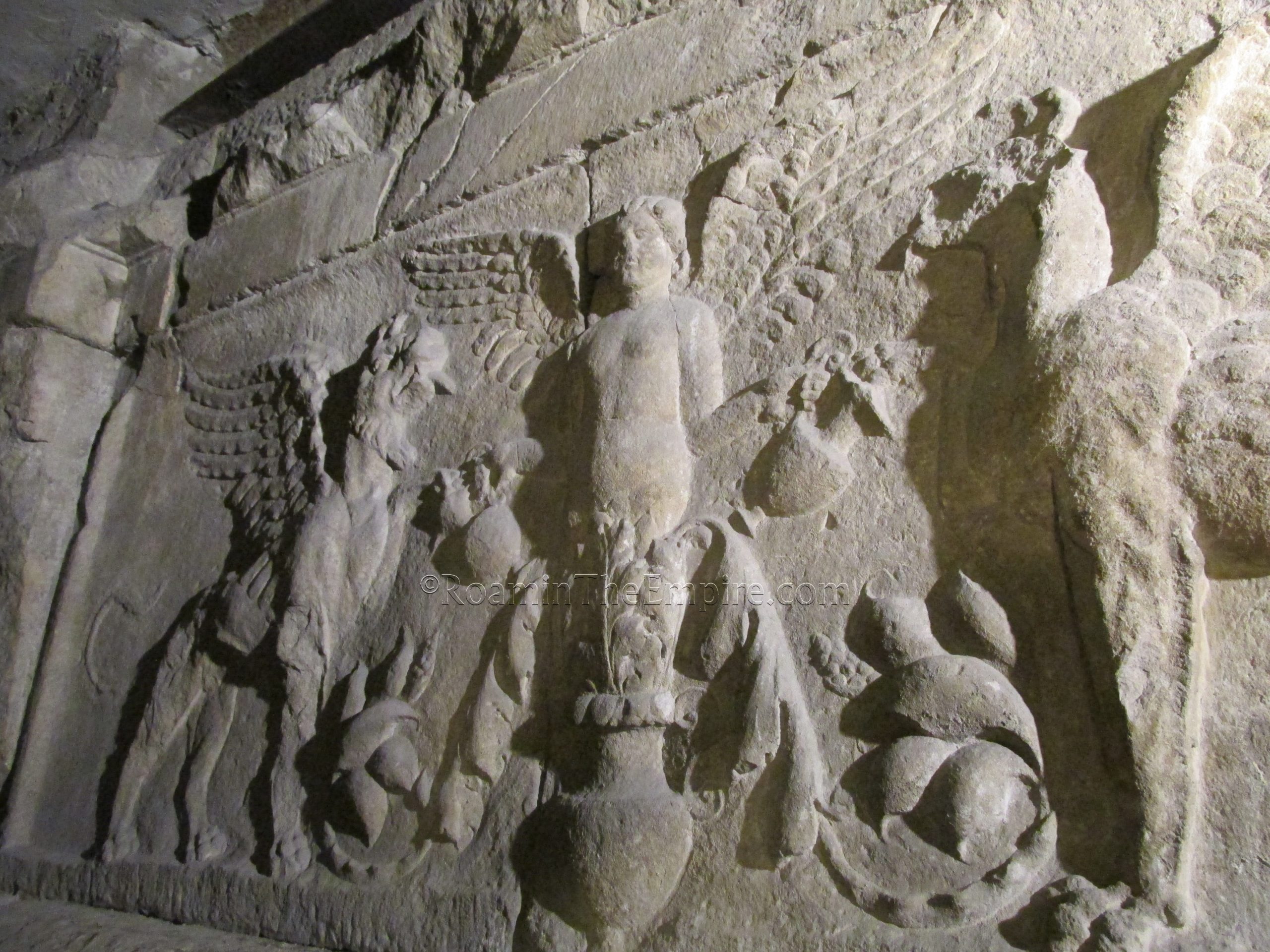 Cupid and griffins relief of the propylaeum, visible within the base of the bell tower. Tergeste.