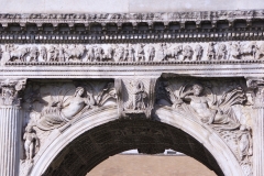 Detail of the center of the north side of the Arch of Trajan. A female figure at center is flanked by the personification of the Tisia on the left and the Danubius on the right. The rivers are flanked by the genius of autumn (left) and genius of winter (right).
