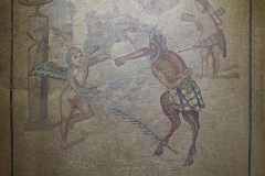 Heavily restored mosaic depicting Cupid and Pan fighting, representing the struggle between love and lust. Psyche is a completely modern addition to the mosaic. From the Casa de Orfeo. Dated to the 2nd century CE. Museo de Zaragoza.
