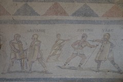 Detail of the gladiator mosaic from the House of Silenus. The names of three of the four combatants are inscribed above the two fights. A summa rudis between the two pairs referees the combat.