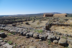 Road with Celtiberian wall and house reconstructions in the background.